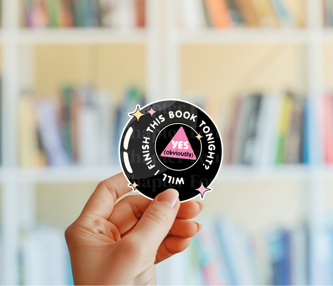 Hand holding a round sticker with text that says 'Will I Finish This Book Tonight? Yes, obviously' in front of a blurred bookshelf