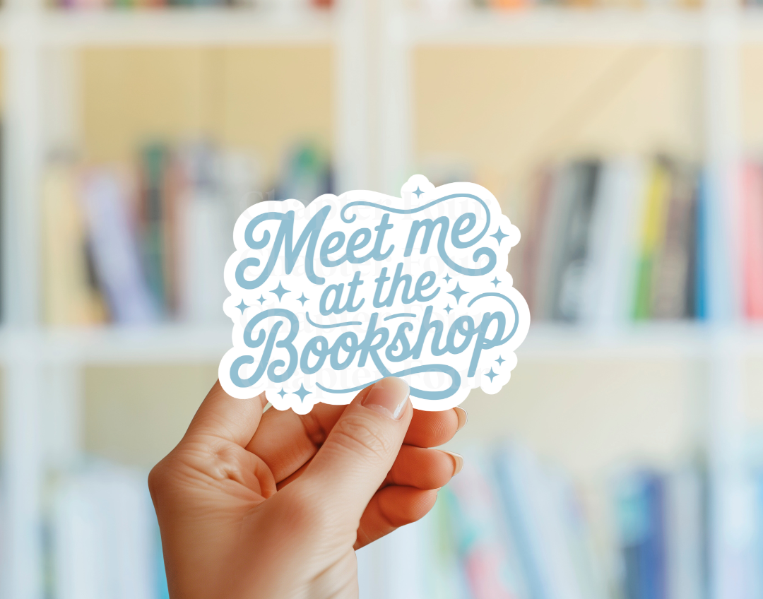 Hand holding a 'Meet me at the Bookshop' sticker in blue text, a blurred bookshelf background