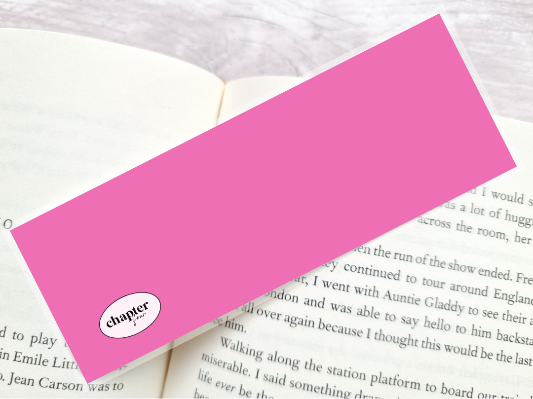 A bright pink rectangular bookmark with a white oval logo reading 'chapter four' lies diagonally across an open book page.
