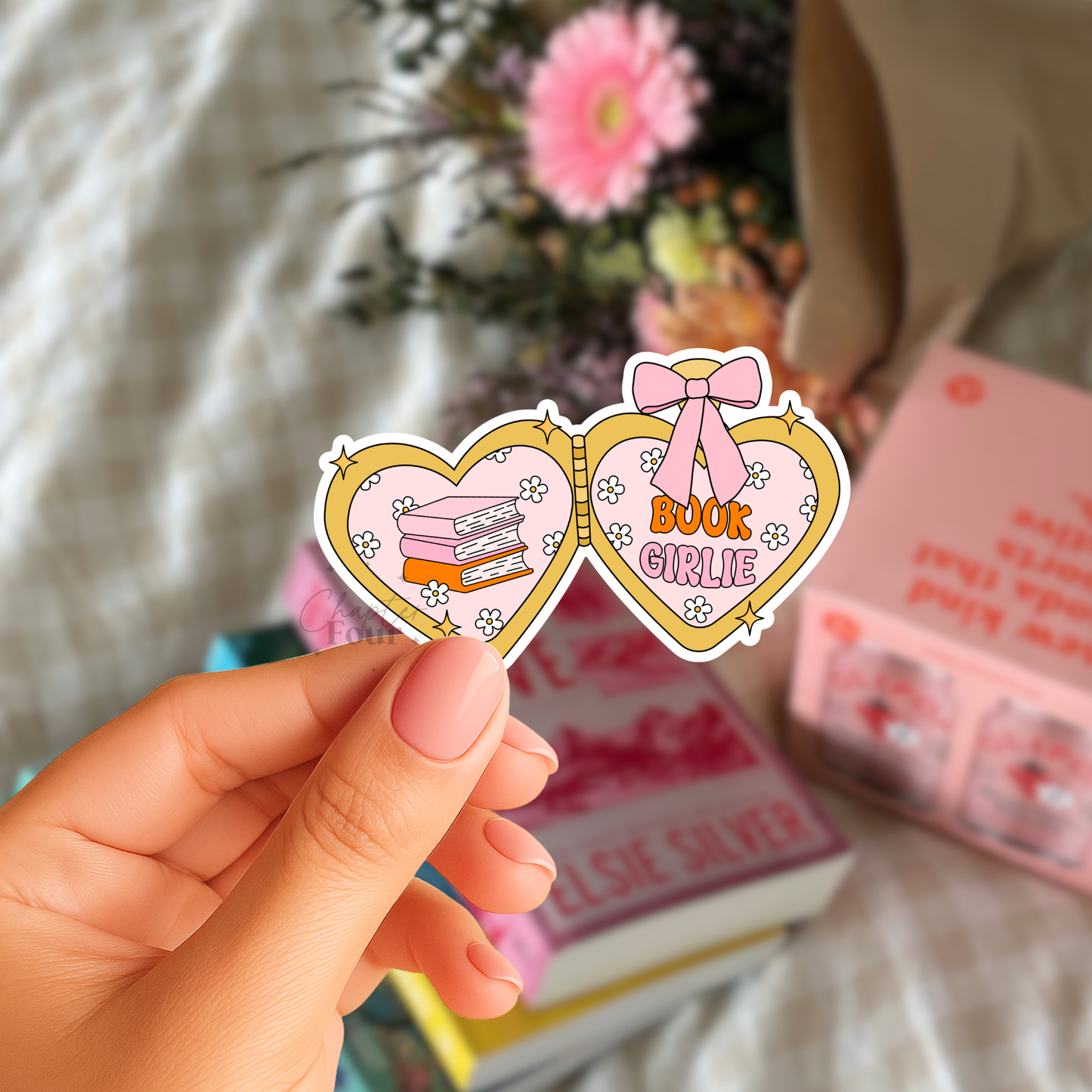 Heart-shaped locket sticker with 'Book Girl' text on the right and 3 stacked books design on the left, held by a hand with blurred books and flowers in the background.