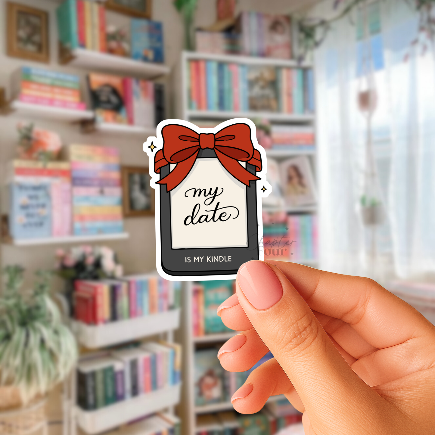 Hand holding a sticker with a Kindle design and 'my date is my Kindle' text in a bookstore setting.
