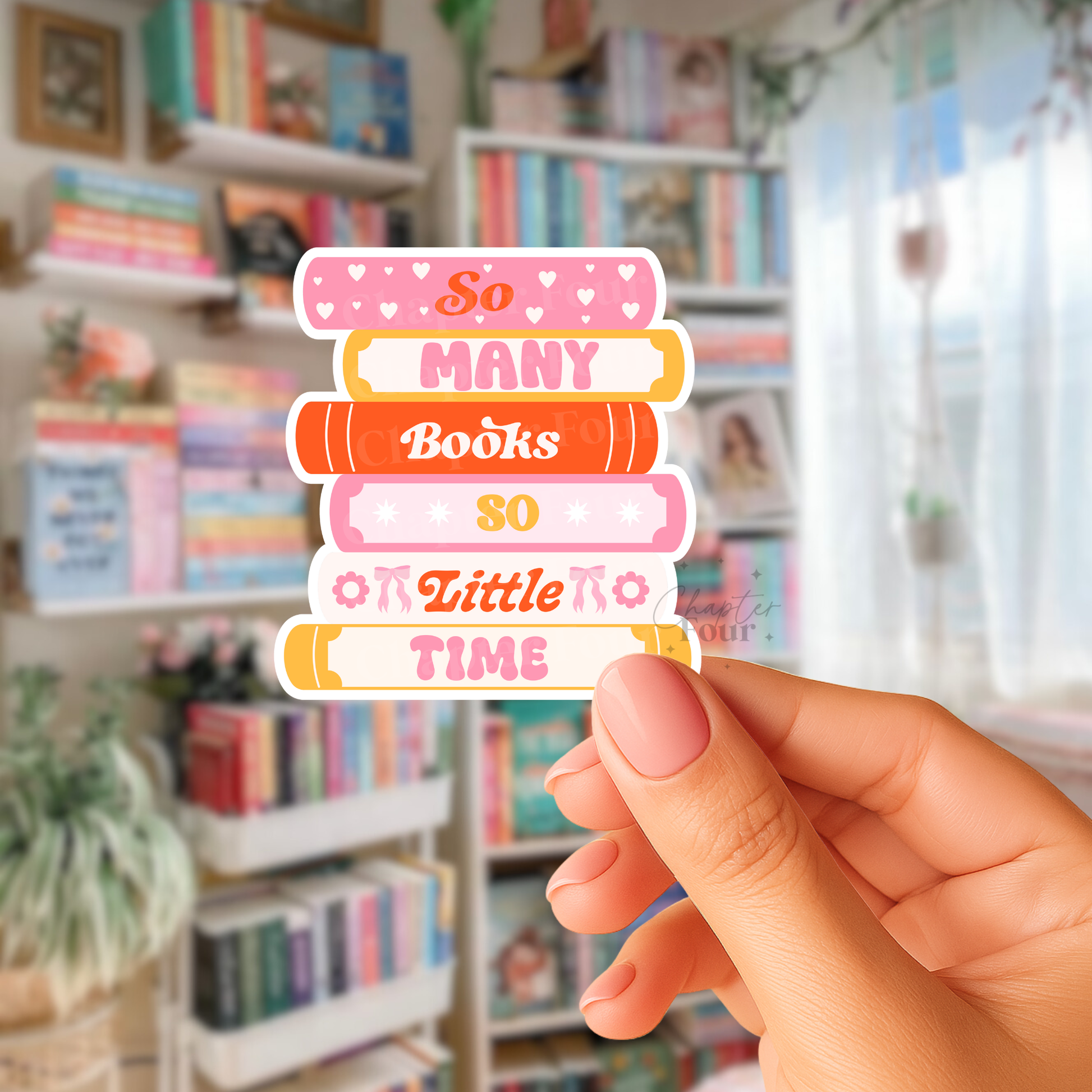 Hand holding a colorful book stack sticker with 'So Many Books So Little Time' text in a library setting