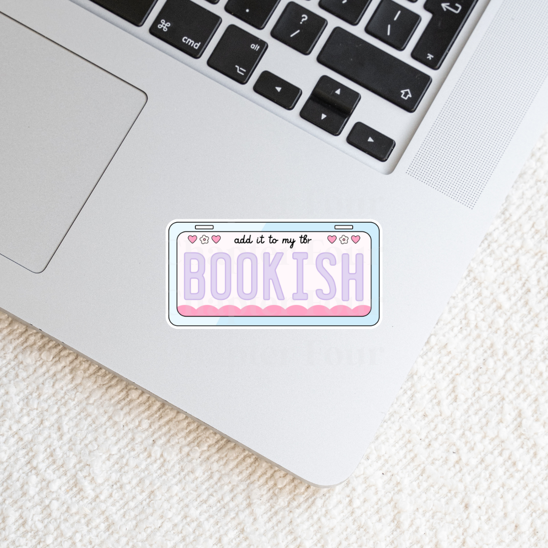 Laptop with a 'add it to my tbr bookish' sticker on a textured surface