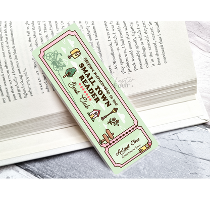 Green bookmark with 'Small Town Reader Book Club' design on an open book