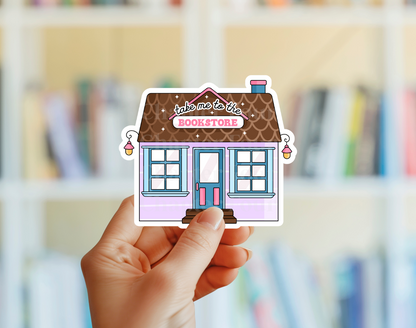Sticker of a bookstore with 'take me to the bookstore' text, held by a hand with a blurred bookshelf background