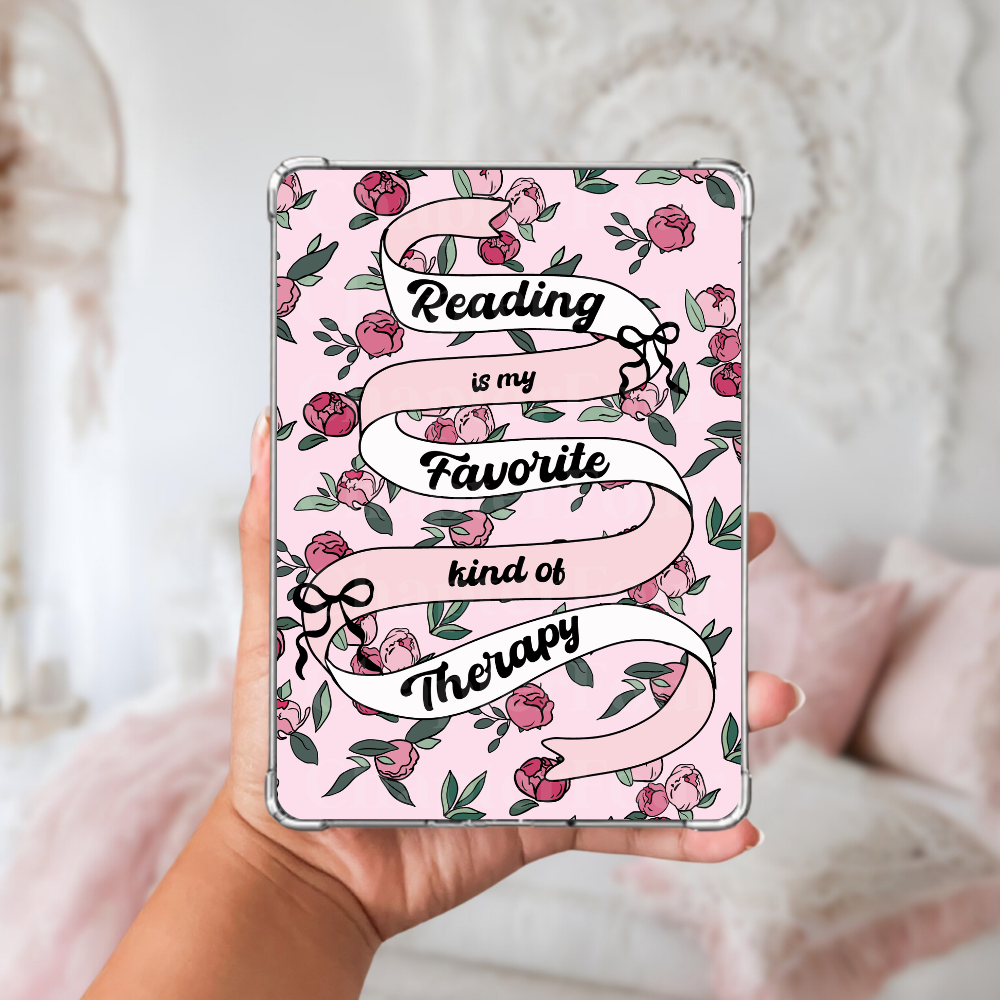 Pink e-reader insert with floral design and text 'Reading is my favorite kind of therapy' held by a hand.